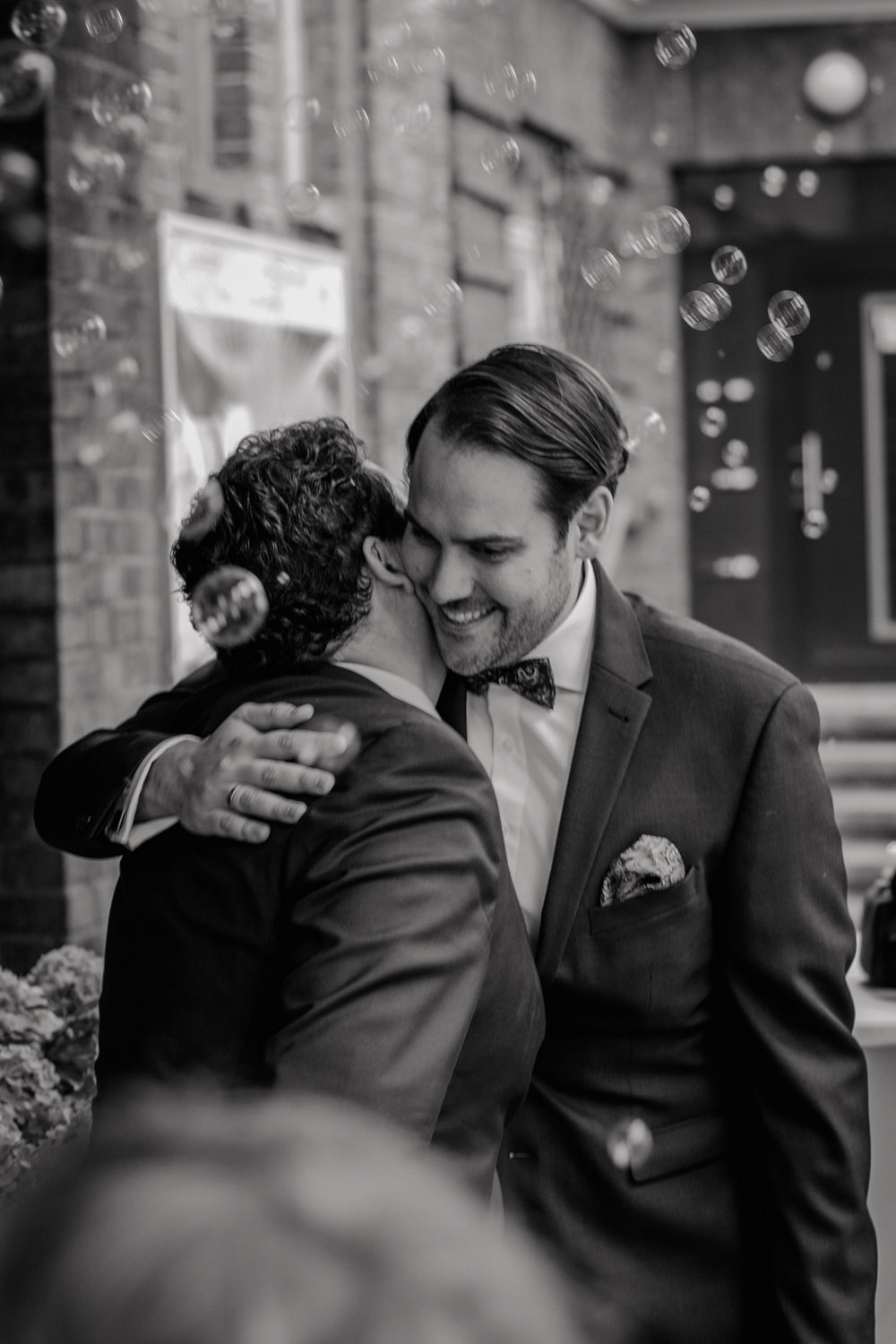 Bräutigam wird nach der Trauung herzlich umarmt