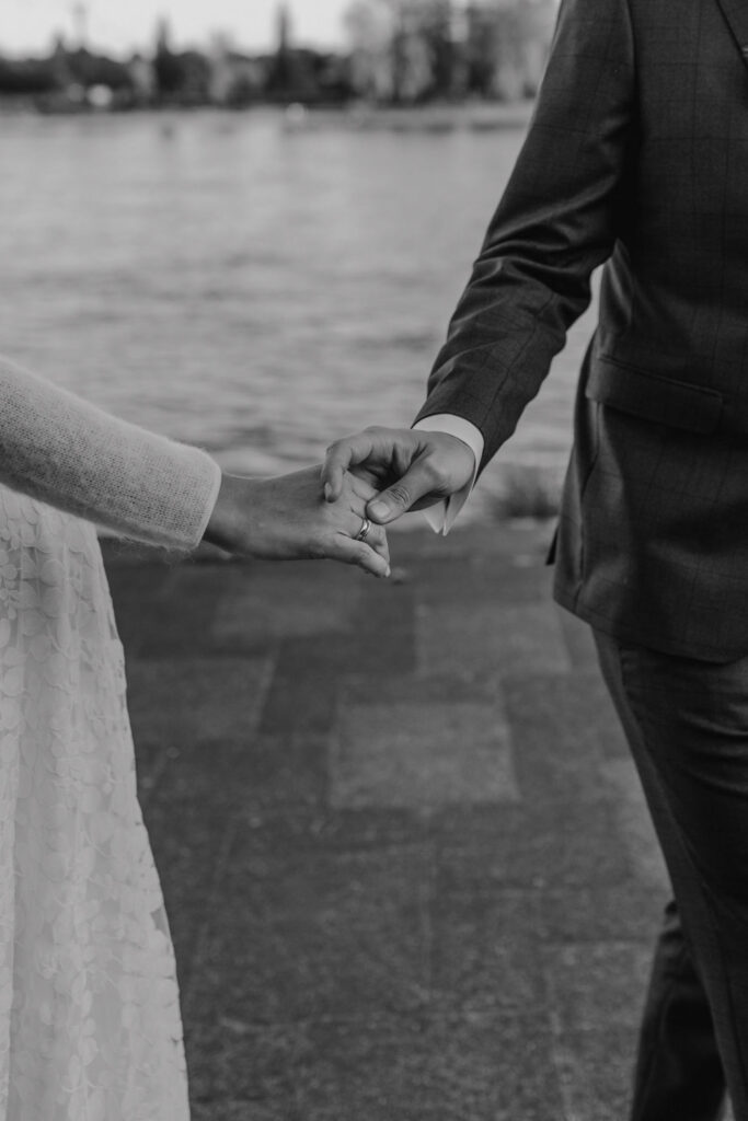 Brautpaar haelt sich an der Rheinpromenade in Koeln an den Haenden