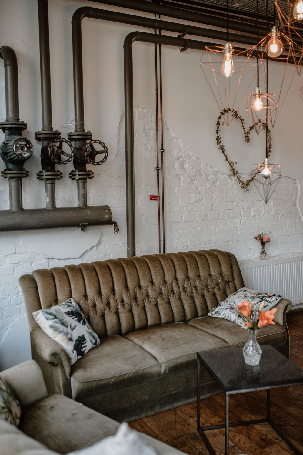 Vintage Sofa mit Herzdeko an Ziegelwand