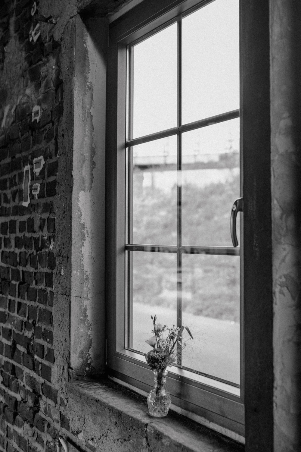 Einzelne Blumenvase auf Fensterbank im Loftstil