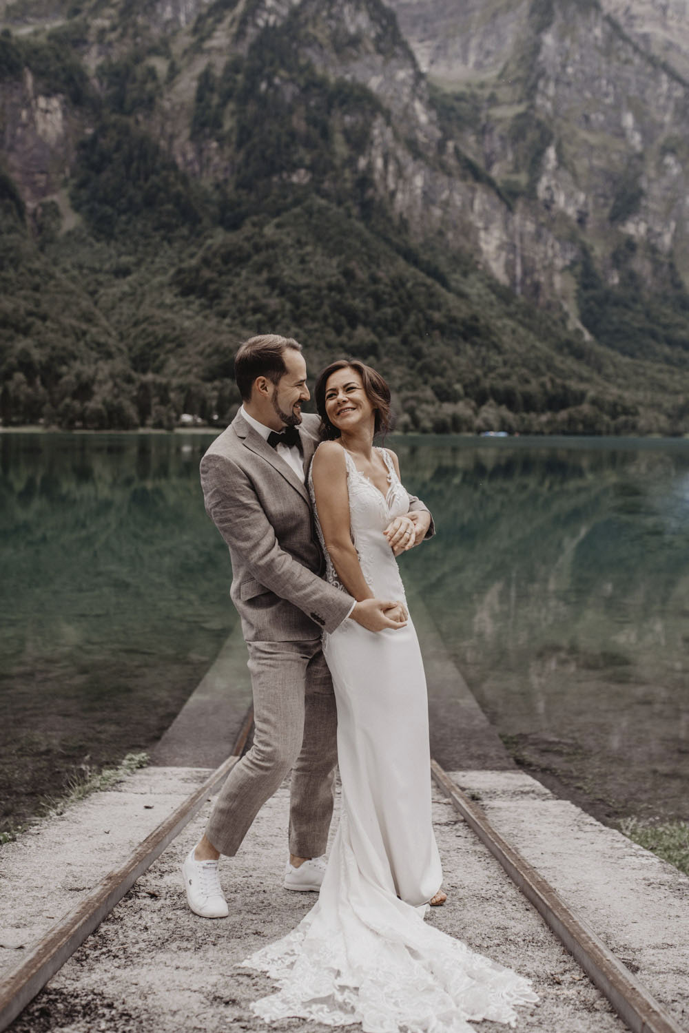 Umarmung des Brautpaars mit Blickkontakt am See