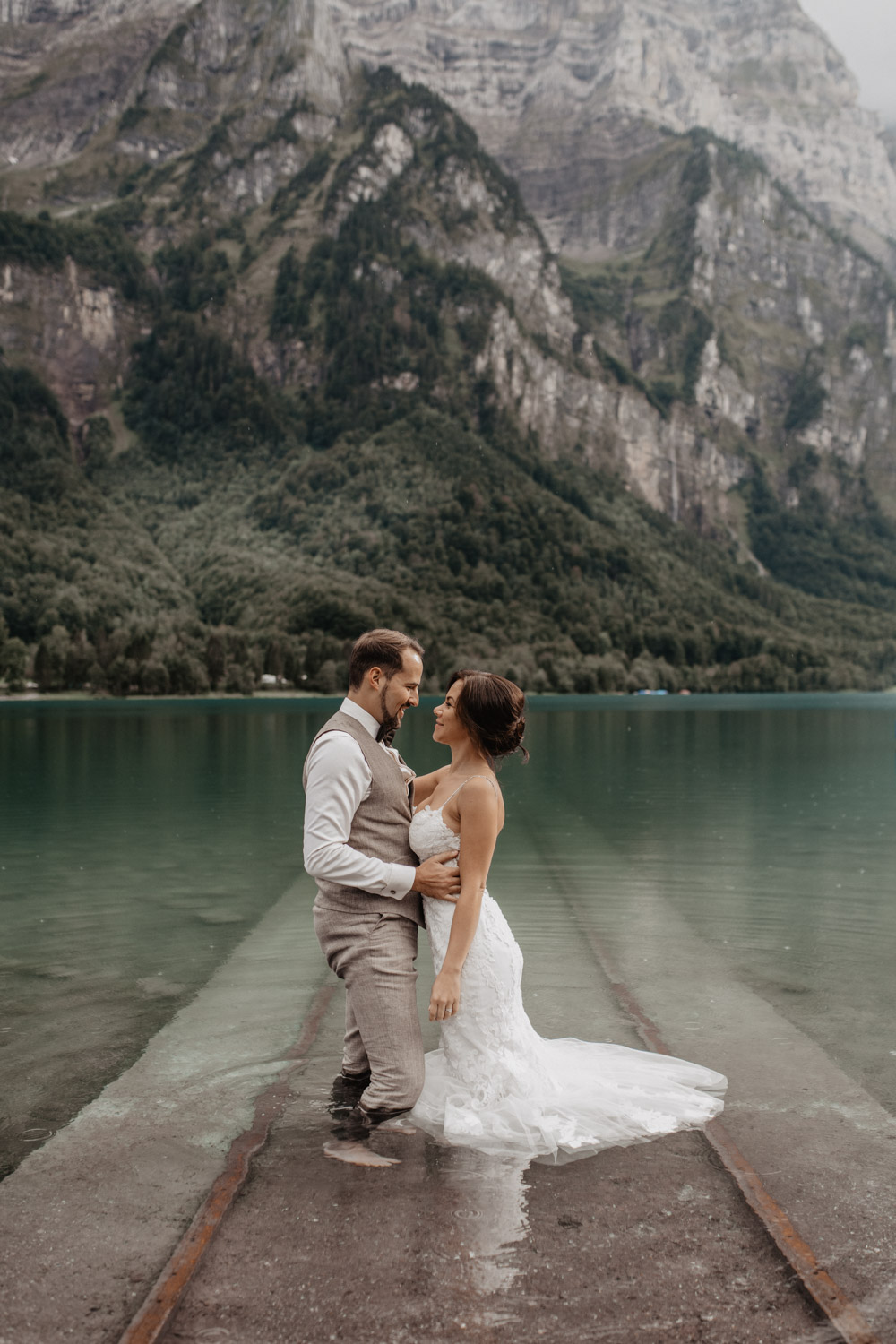 Brautpaar steht im flachen Wasser des Klöntalersees