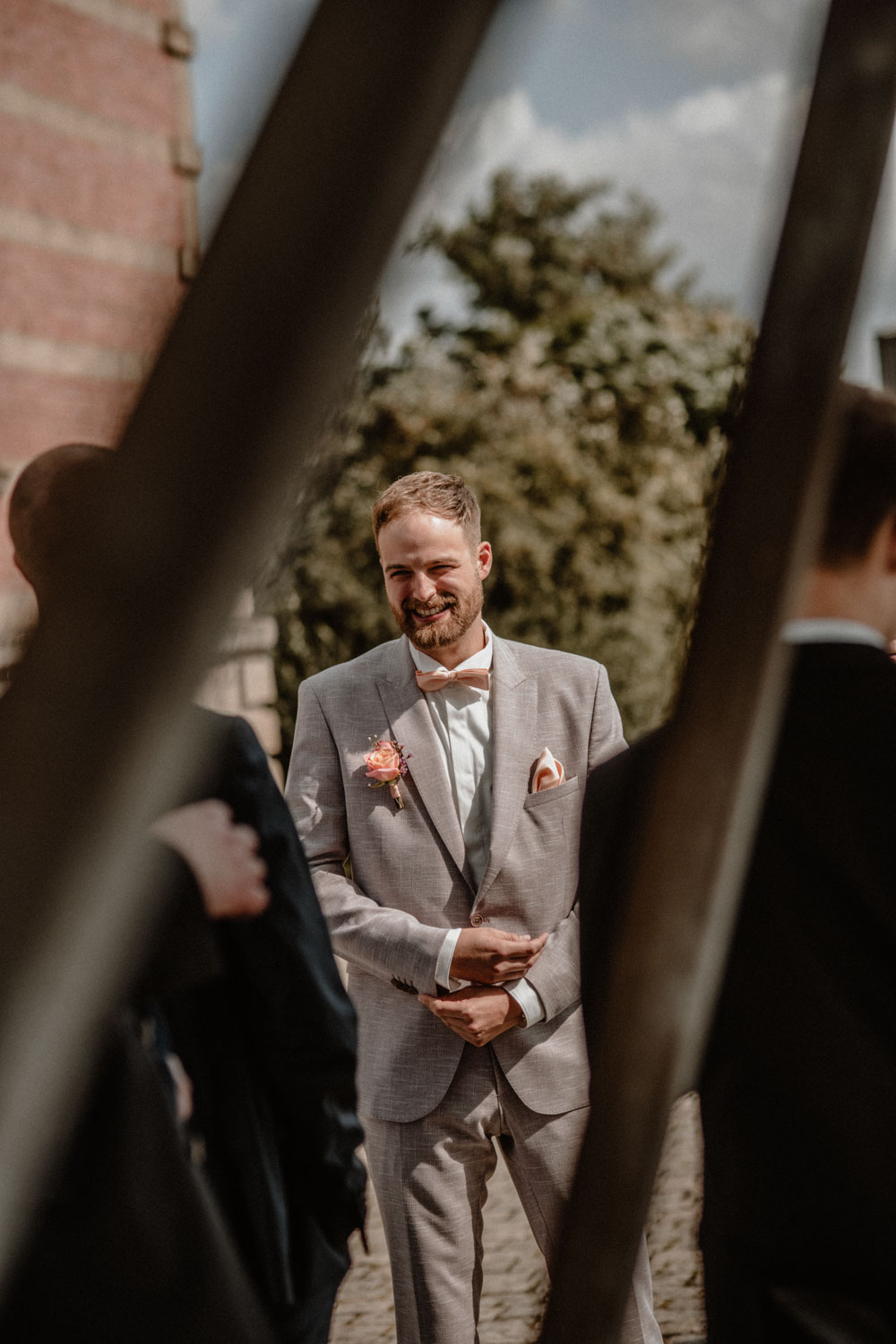 Bräutigam lächelt in Richtung Gäste