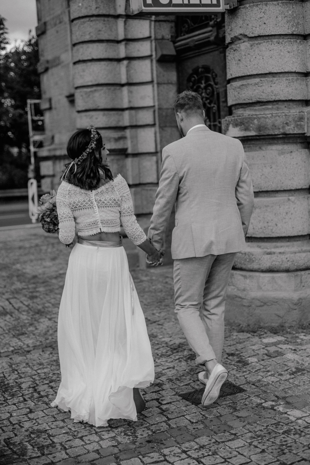 Brautpaar läuft Hand in Hand Richtung Hafenamt