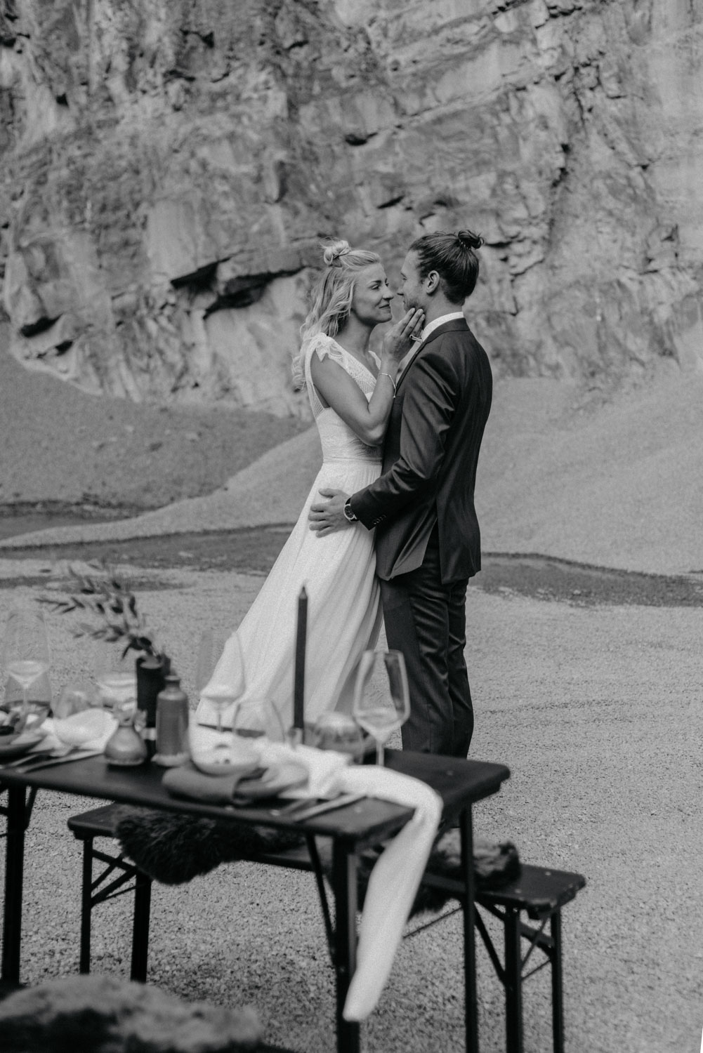 Bräutigam hebt Braut auf dem Tisch in Schwarz-Weiß