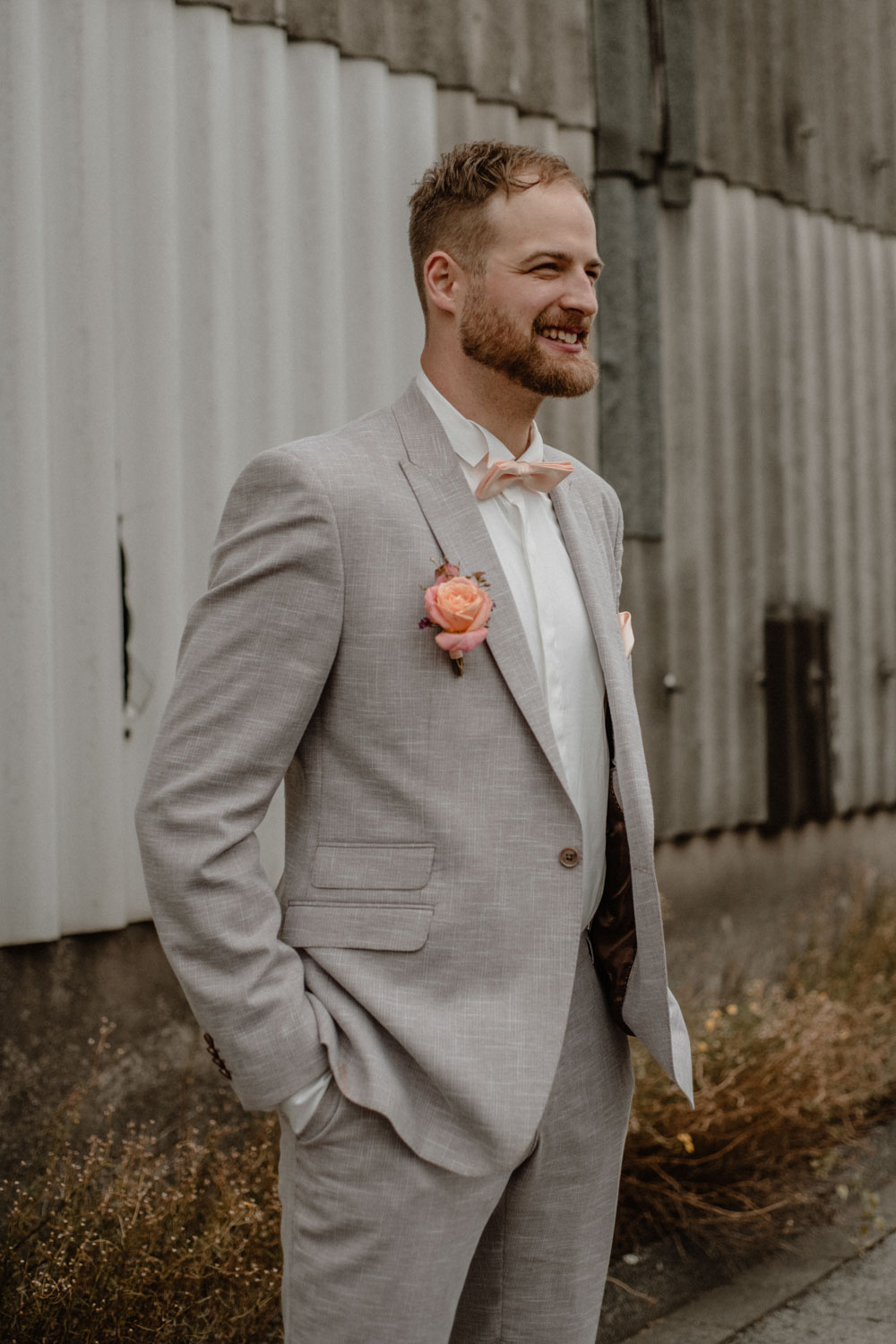 Bräutigam lacht im grauen Anzug