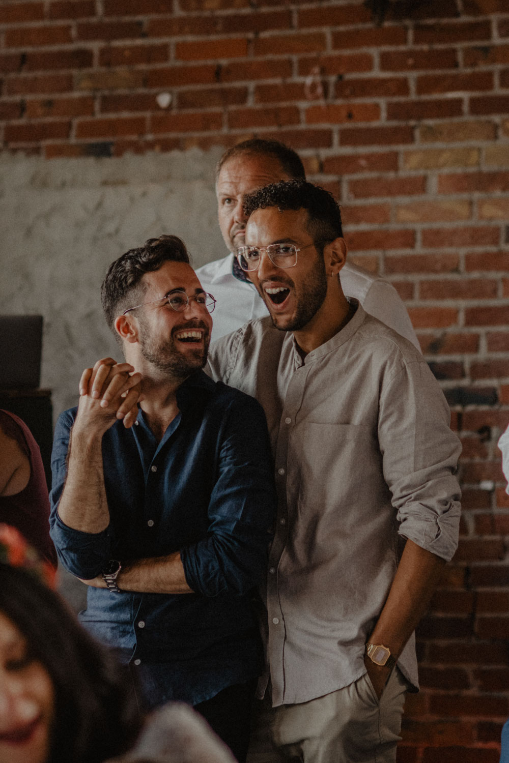 Zwei Männer lachen verliebt bei Hochzeit