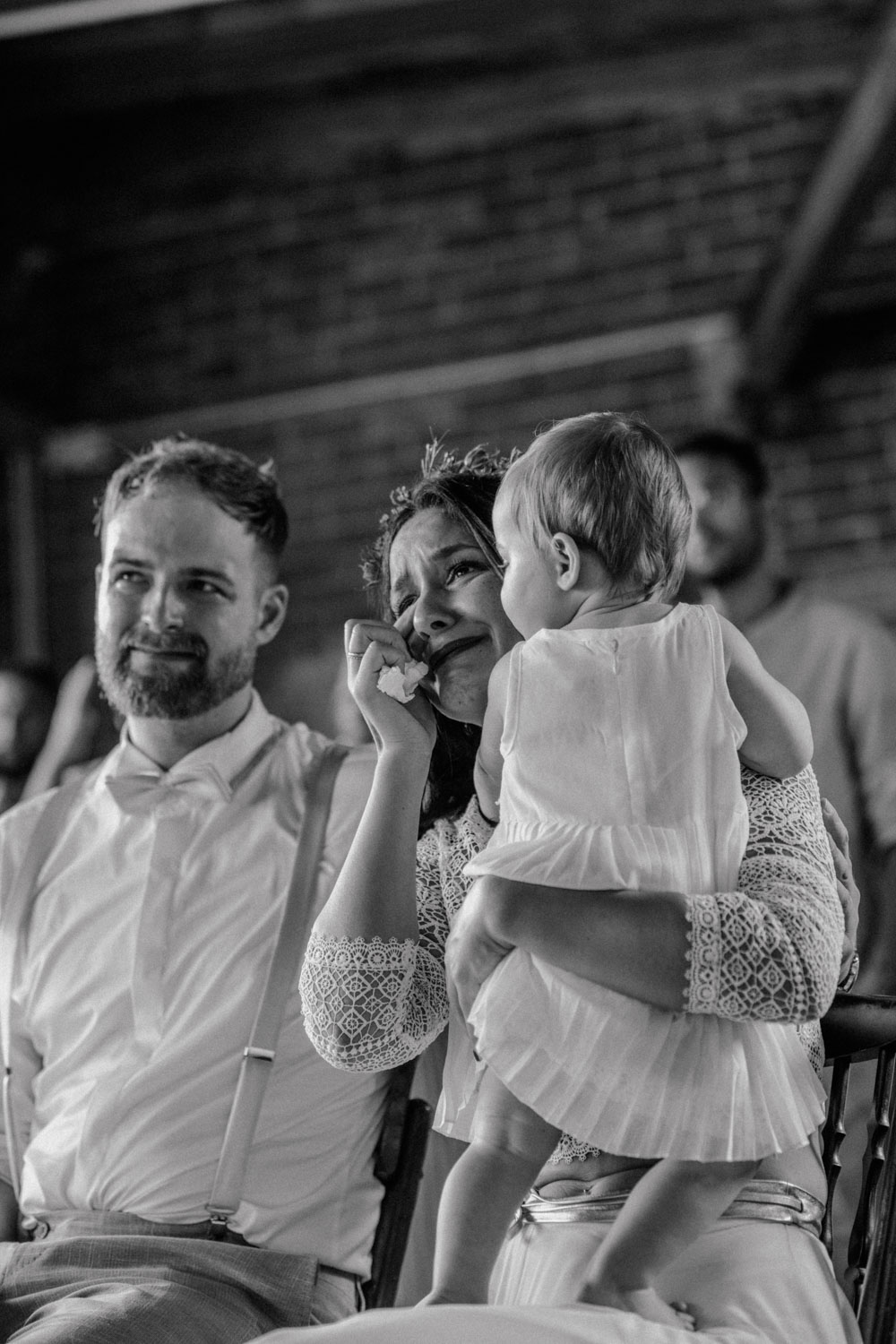 Braut weint gerührt mit Baby auf dem Schoß