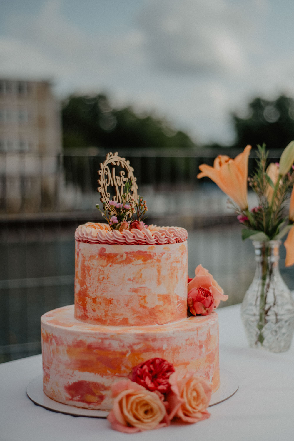 Zweistöckige Hochzeitstorte mit orangen Rosen