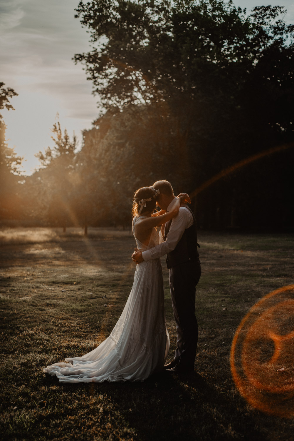 Brautpaar umarmt sich im Gegenlicht der Abendsonne