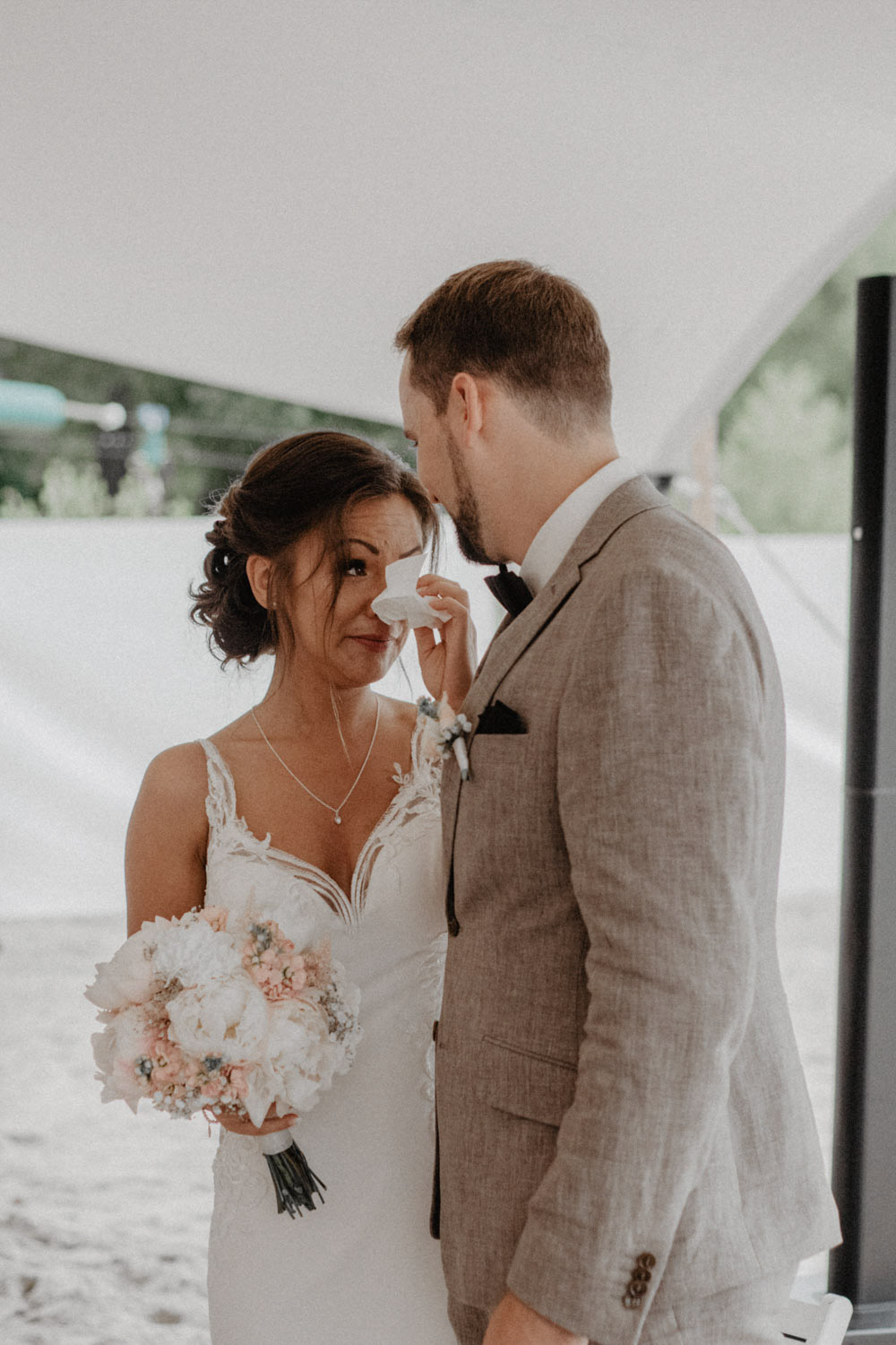 Braut wischt sich eine Träne aus dem Gesicht bei der Trauung