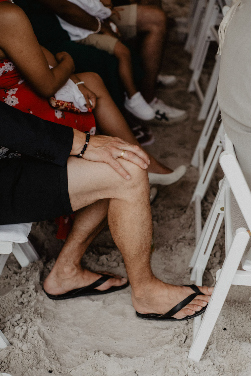Gast mit Flipflops auf Sandboden der Hochzeit
