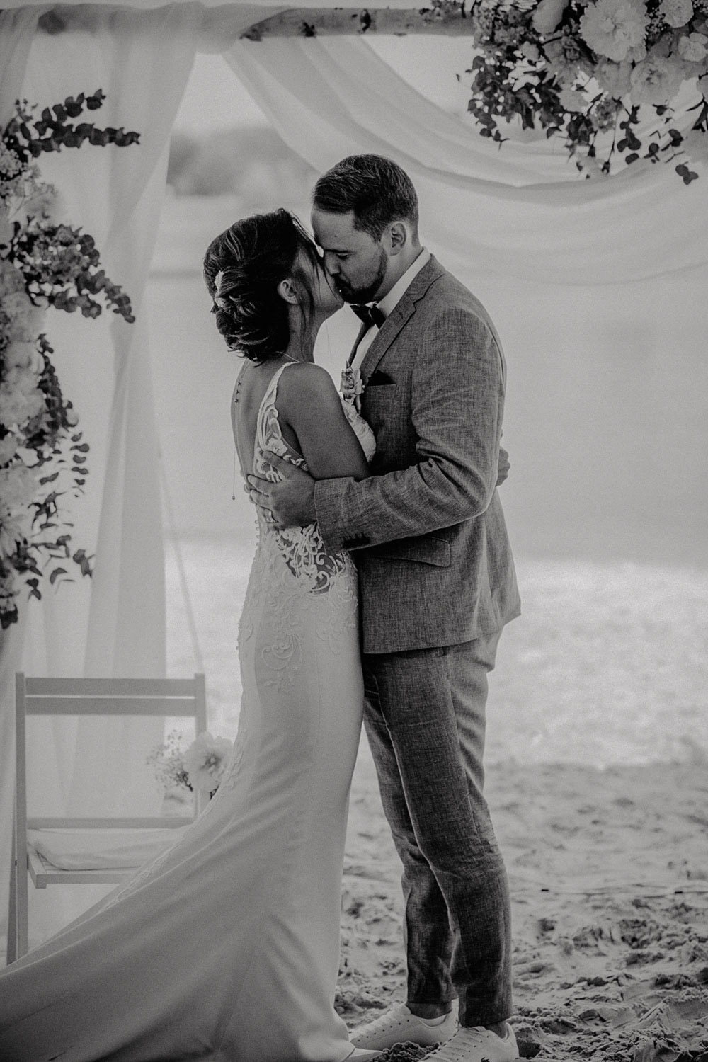 Erster Kuss des Brautpaares am Traubogen