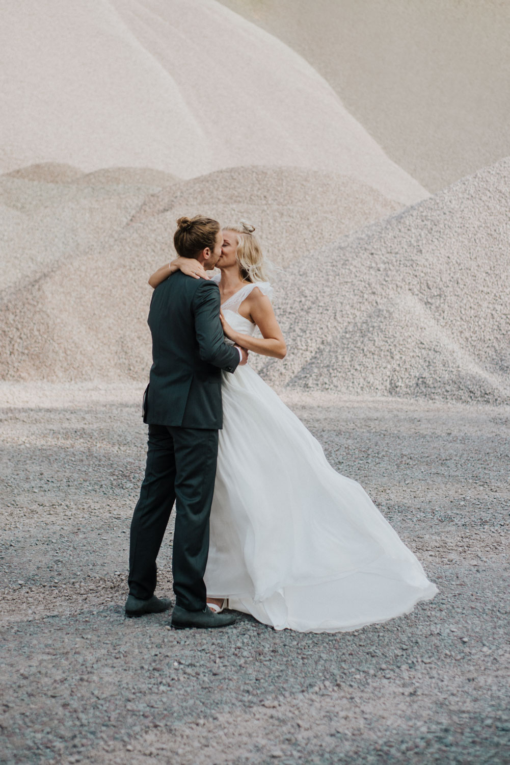 Braut und Bräutigam stehen eng aneinander vor der Wand