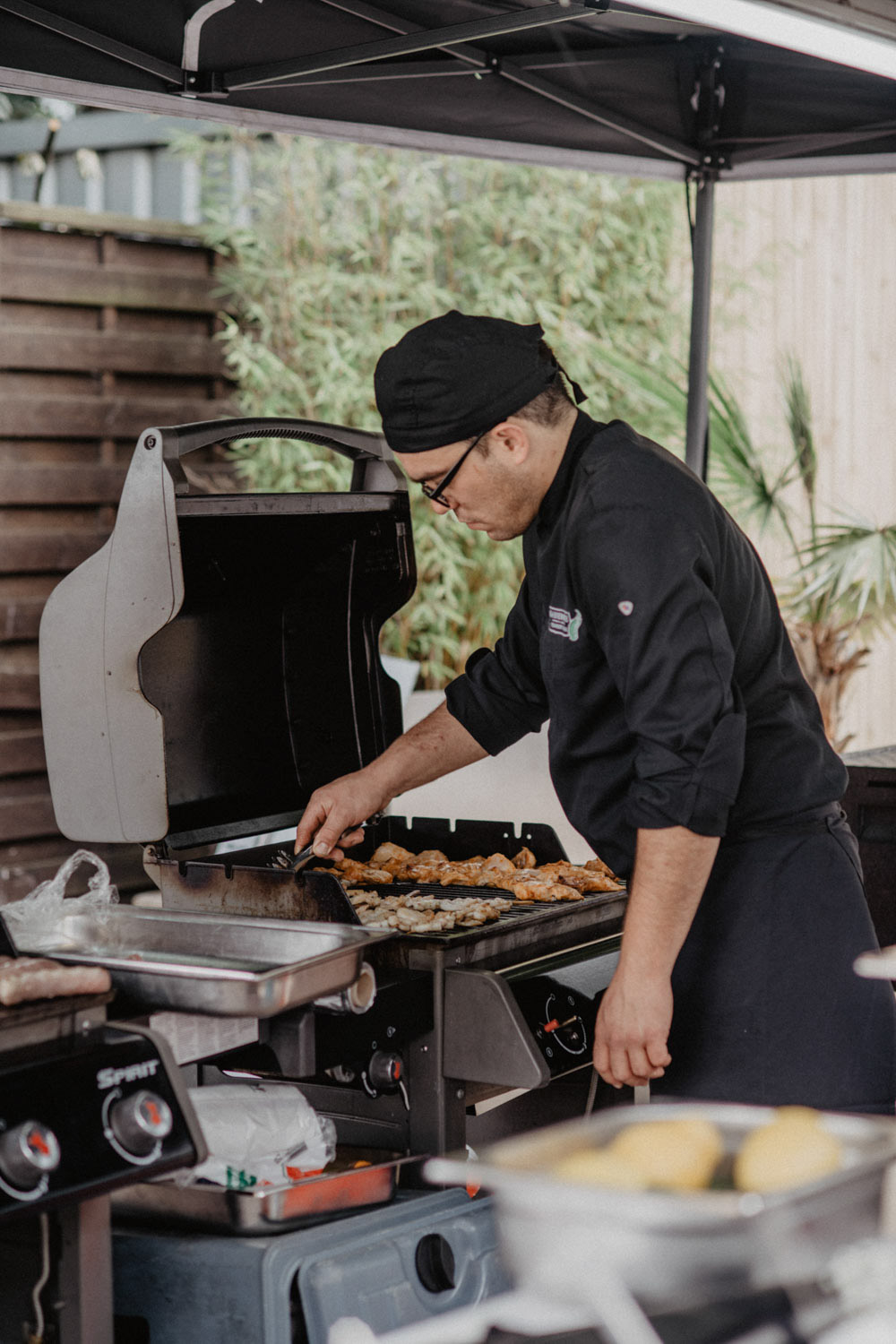 Grillmeister bereitet Fleisch für Hochzeitsgäste am See