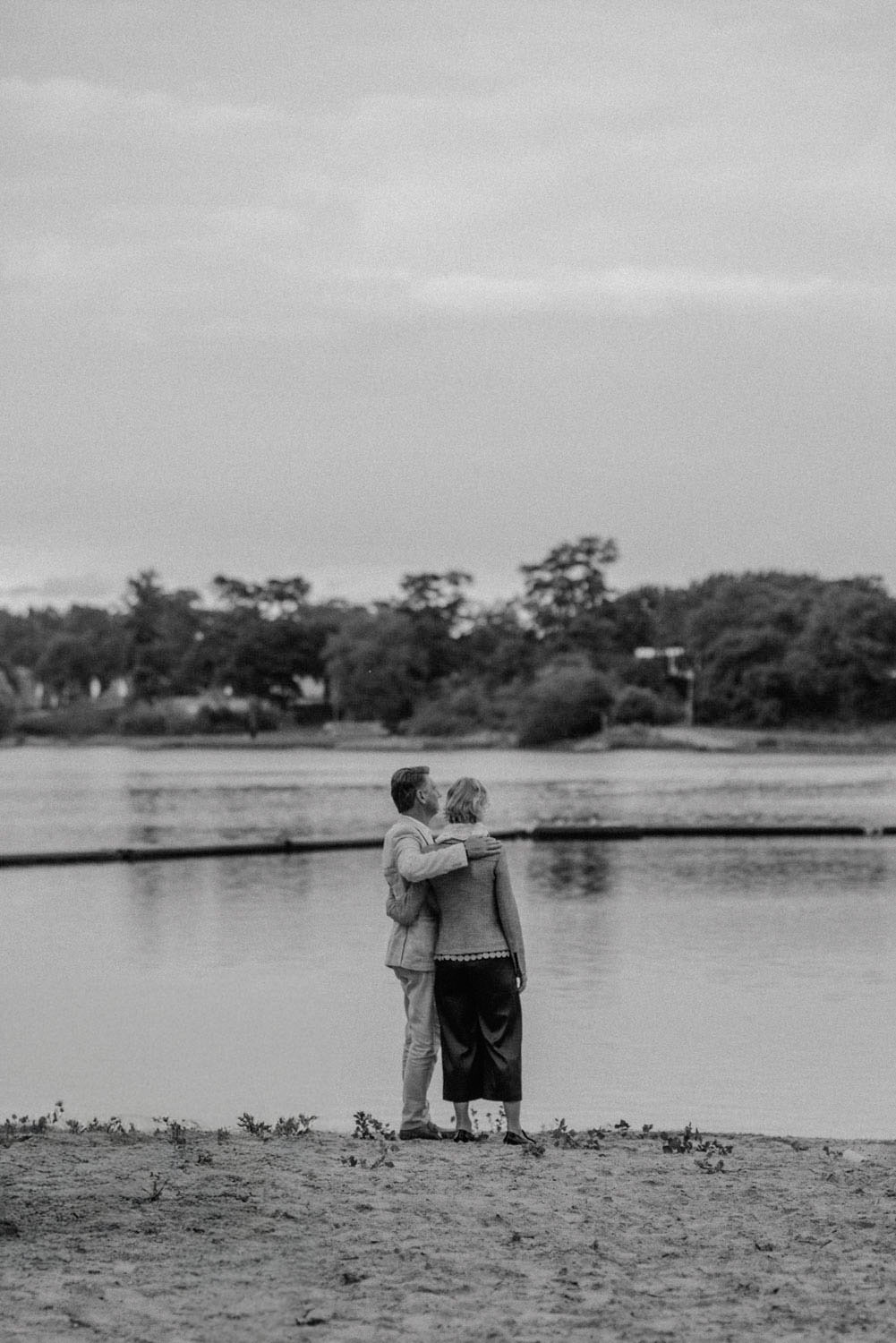 Paar blickt Arm in Arm über den Fühlinger See