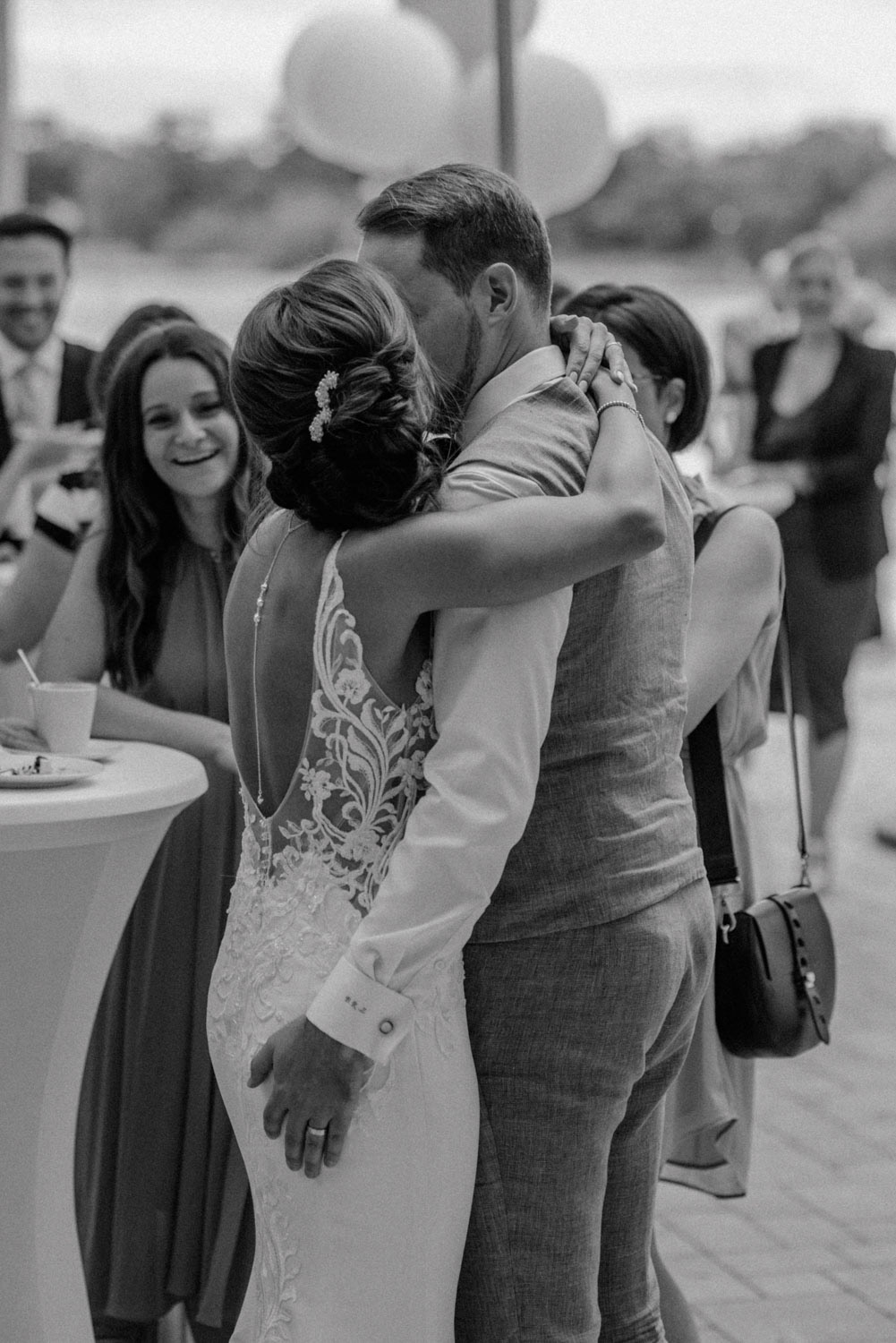 Brautpaar küsst sich vor applaudierenden Gästen am Fühlinger See