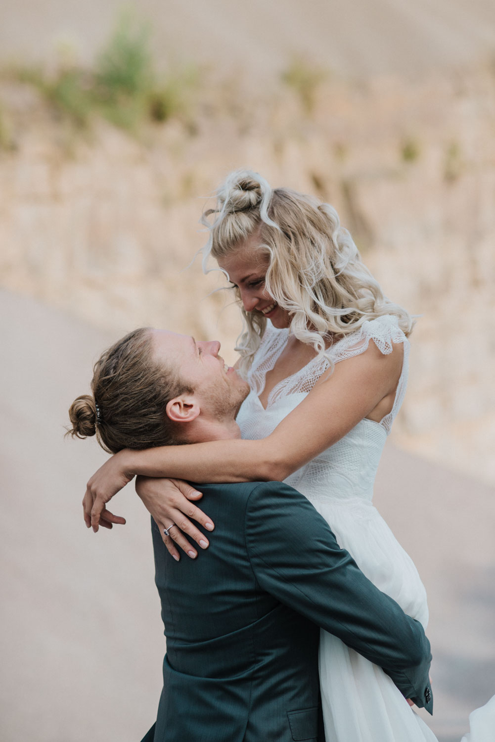 Bräutigam hebt die Braut lachend hoch