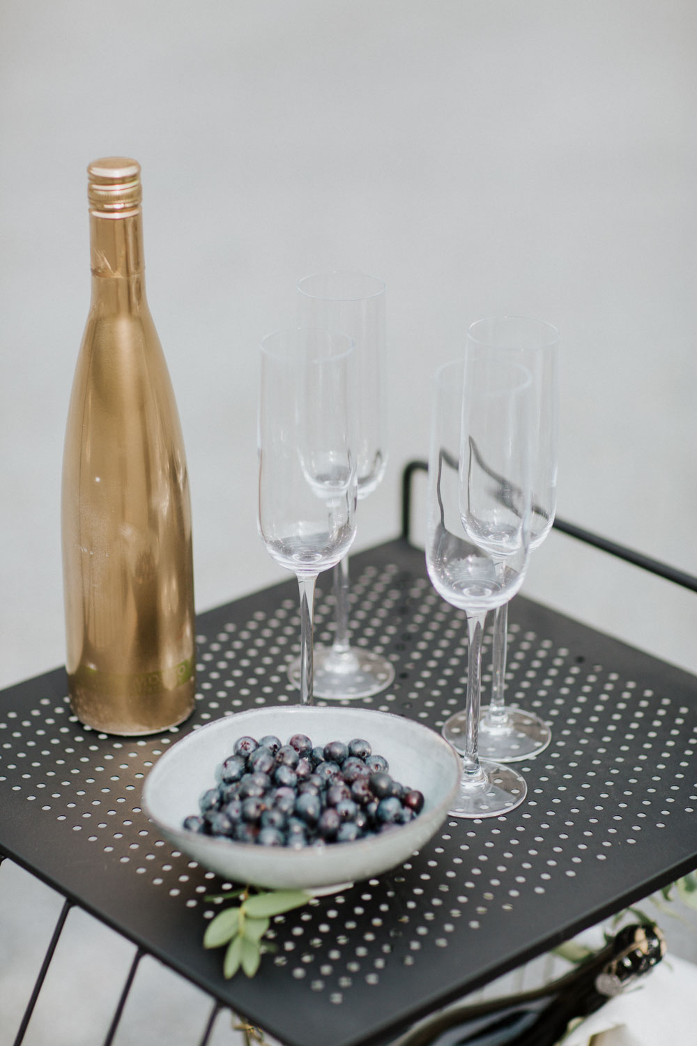 Gläser und goldene Flasche auf schwarzem Tisch