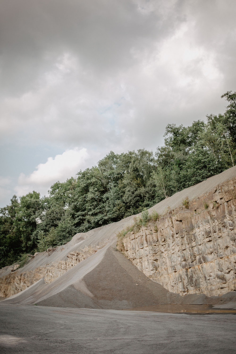 Blick über den weiten Steinbruch mit bewaldetem Rand
