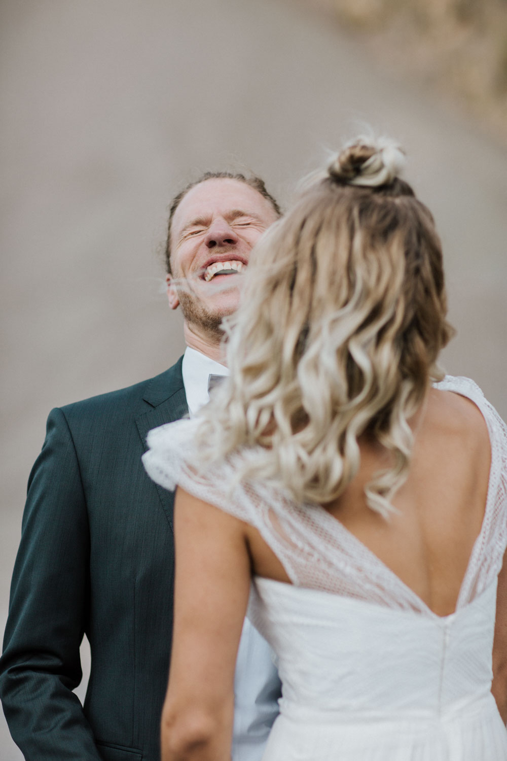 Bräutigam lacht herzlich, Braut mit dem Rücken zur Kamera