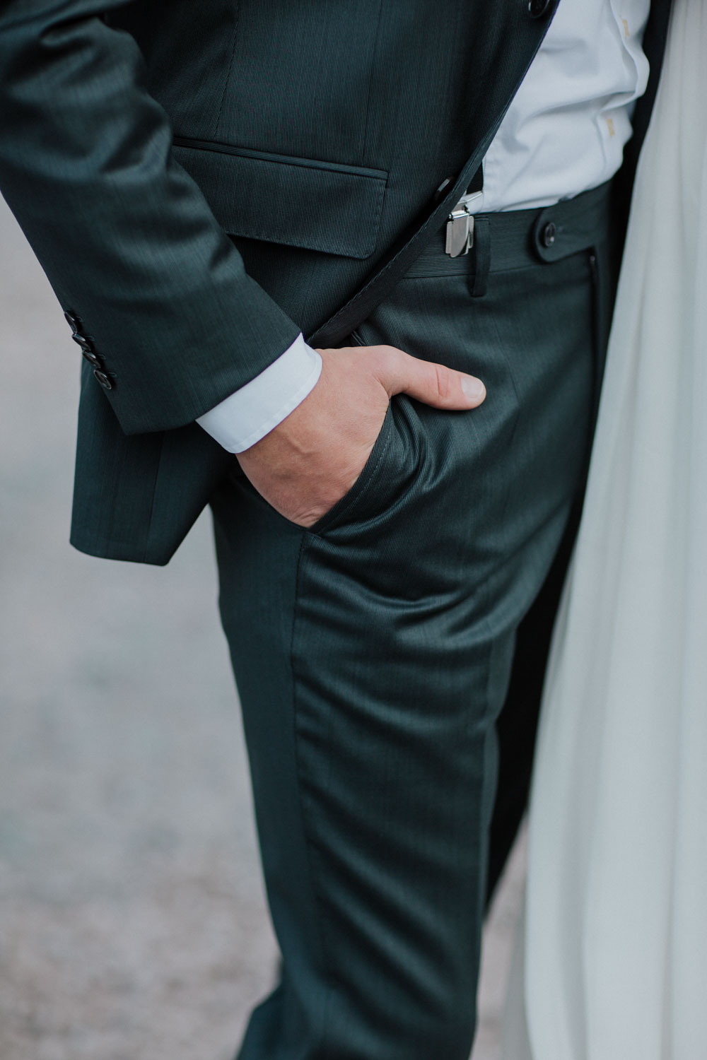 Ausschnitt des Brautpaars mit Fokus auf Anzug und Kleid