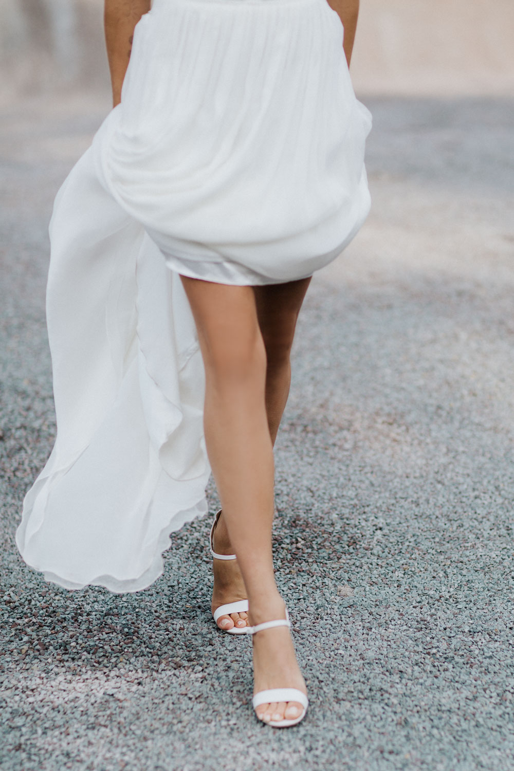 Braut hebt Kleid beim Gehen, Fokus auf Beine und Bewegung