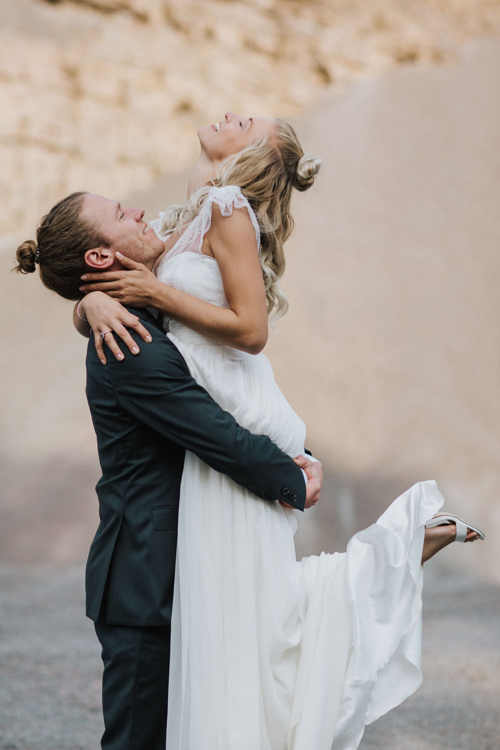 Bräutigam hebt Braut auf, sie wirft den Kopf zurück