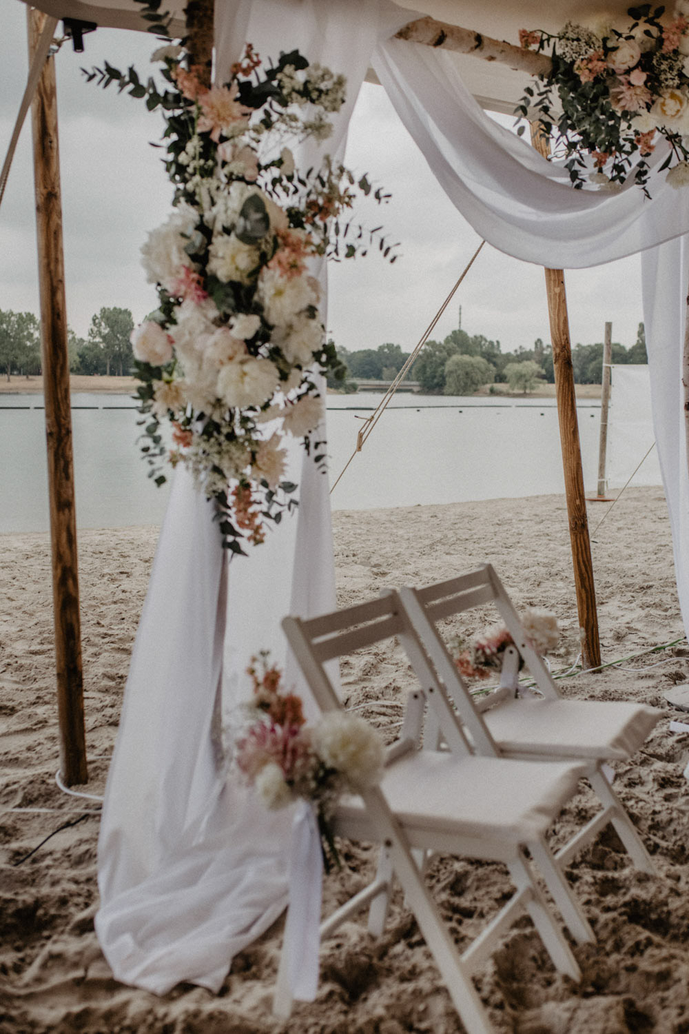 Zeremoniebogen mit weißen Stoffen und Blumen am Fühlinger See