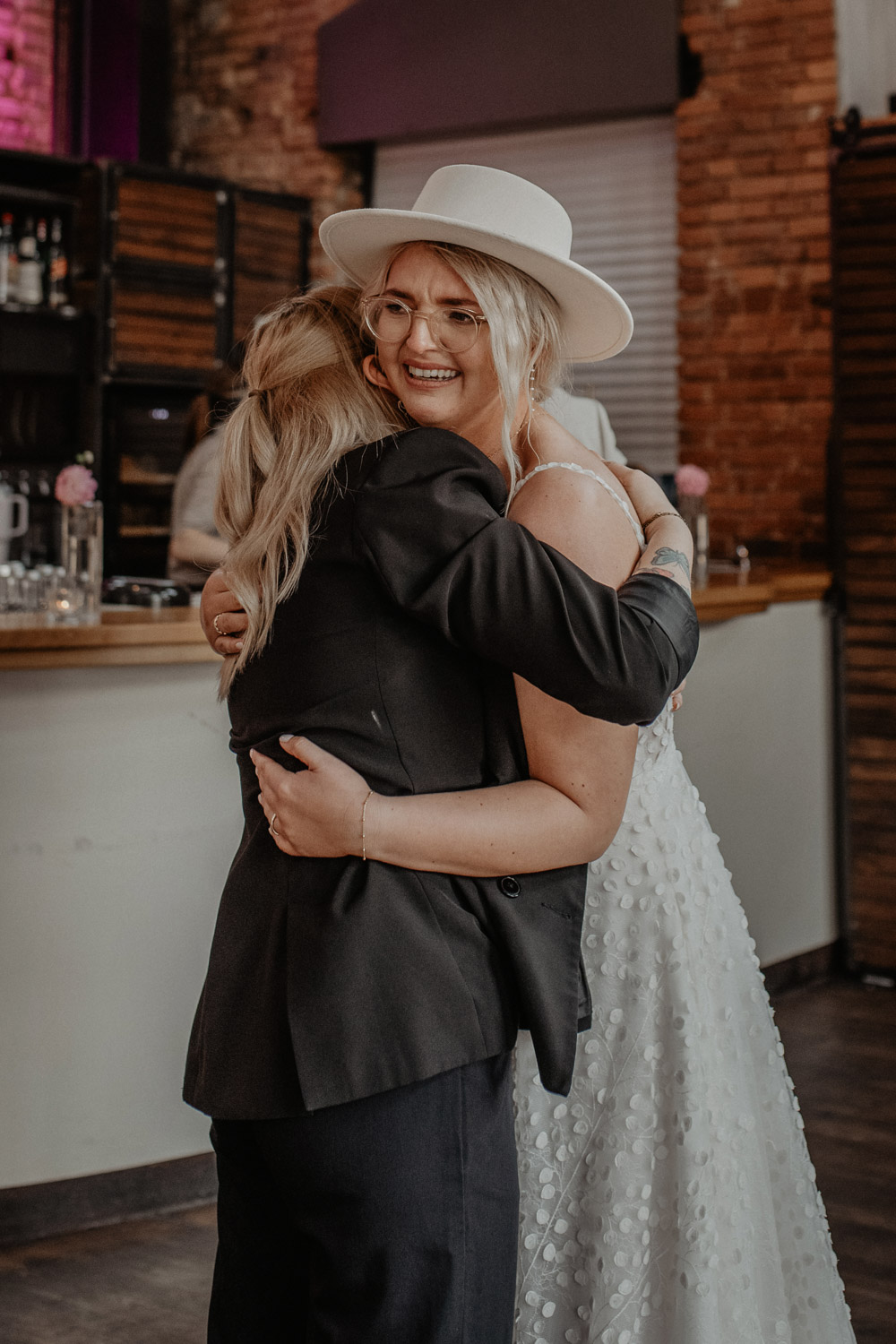 Braut umarmt Freundin herzlich in der Hochzeitslocation