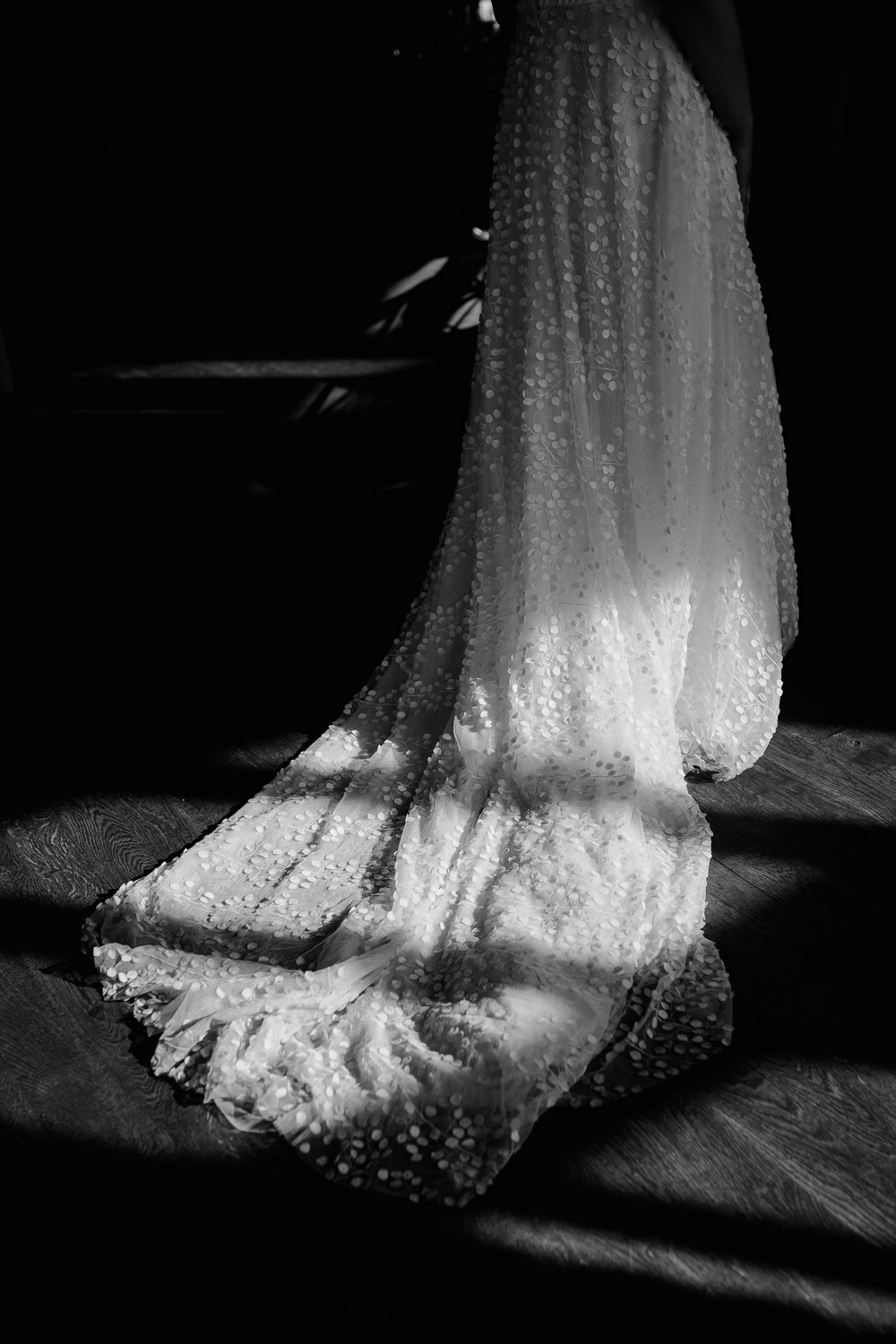 Licht fällt auf den fließenden Tüll des Brautkleids