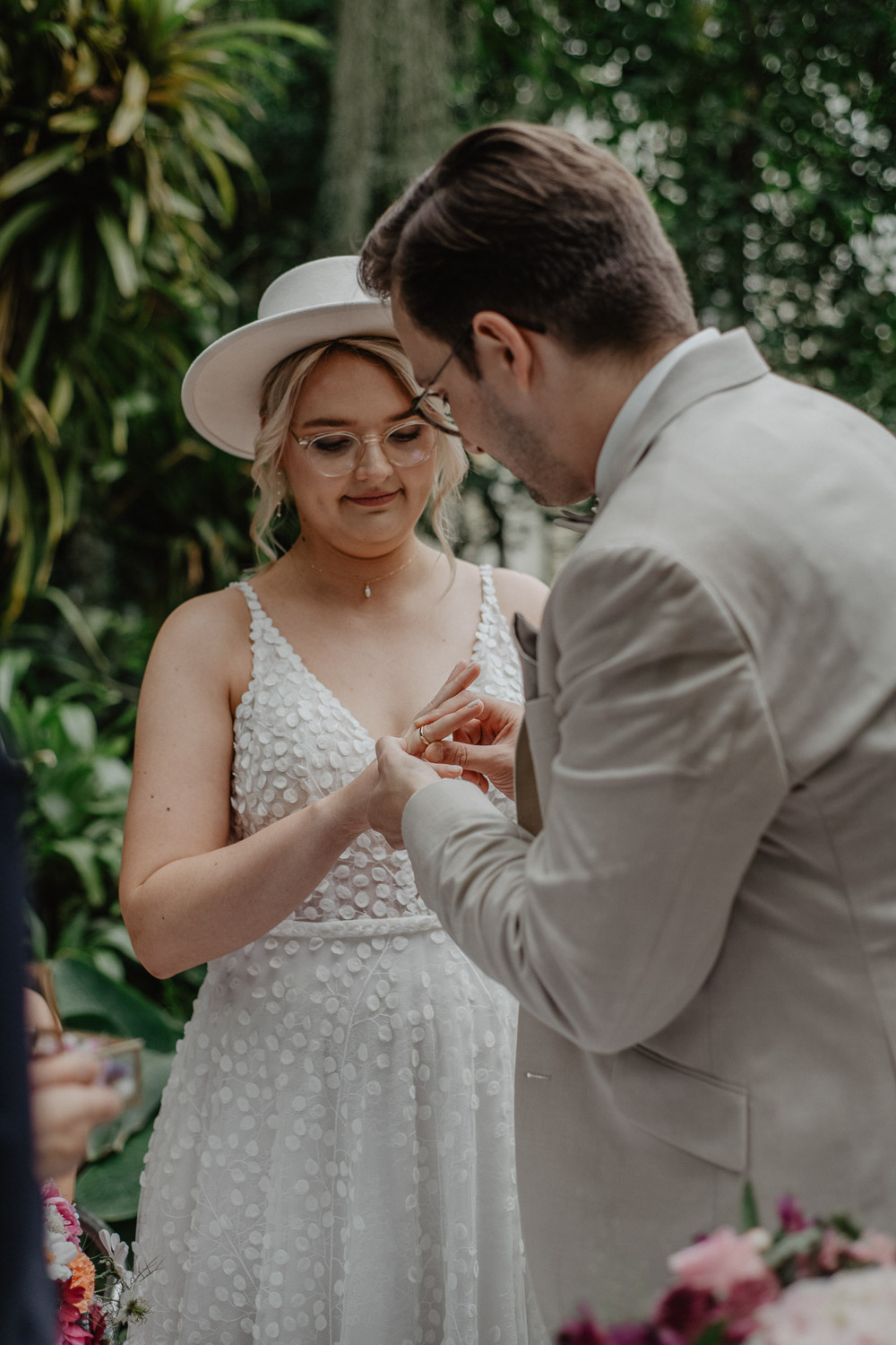Bräutigam steckt der Braut den Ring im Regenwaldhaus an