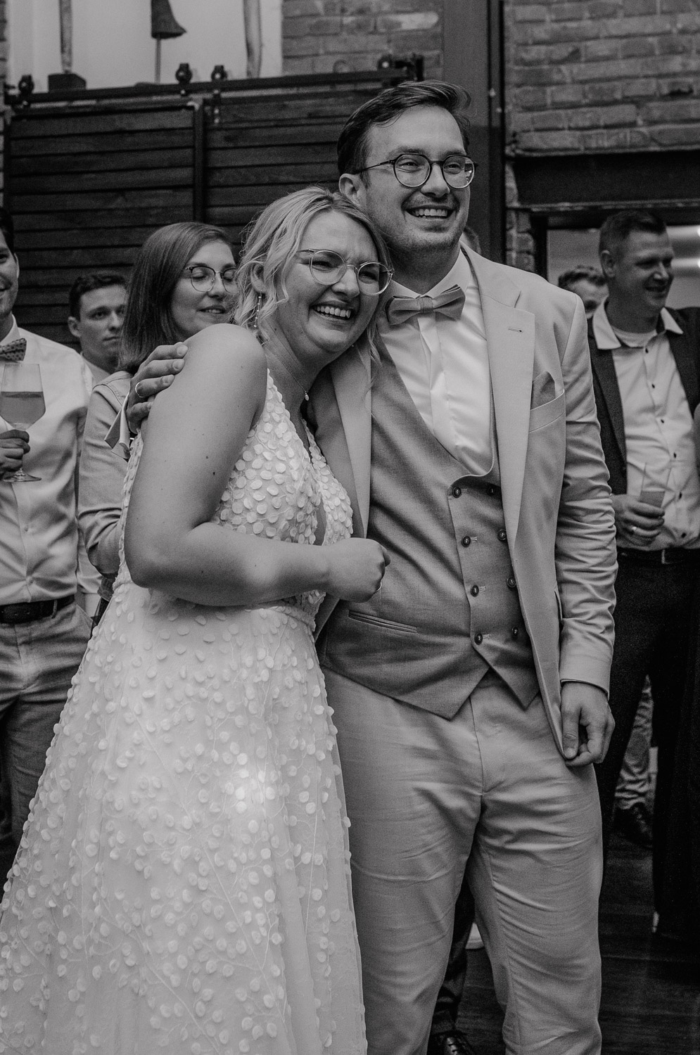 Brautpaar lacht und umarmt sich bei der Hochzeitsfeier