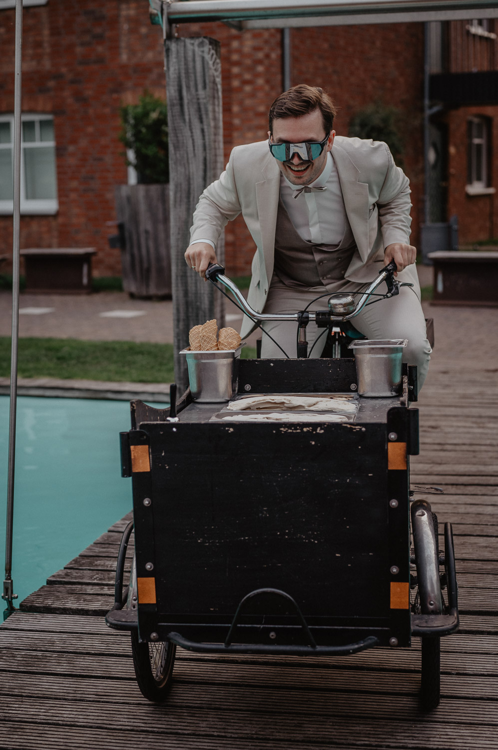 Bräutigam fährt Eisfahrrad am Pool bei der Hochzeit
