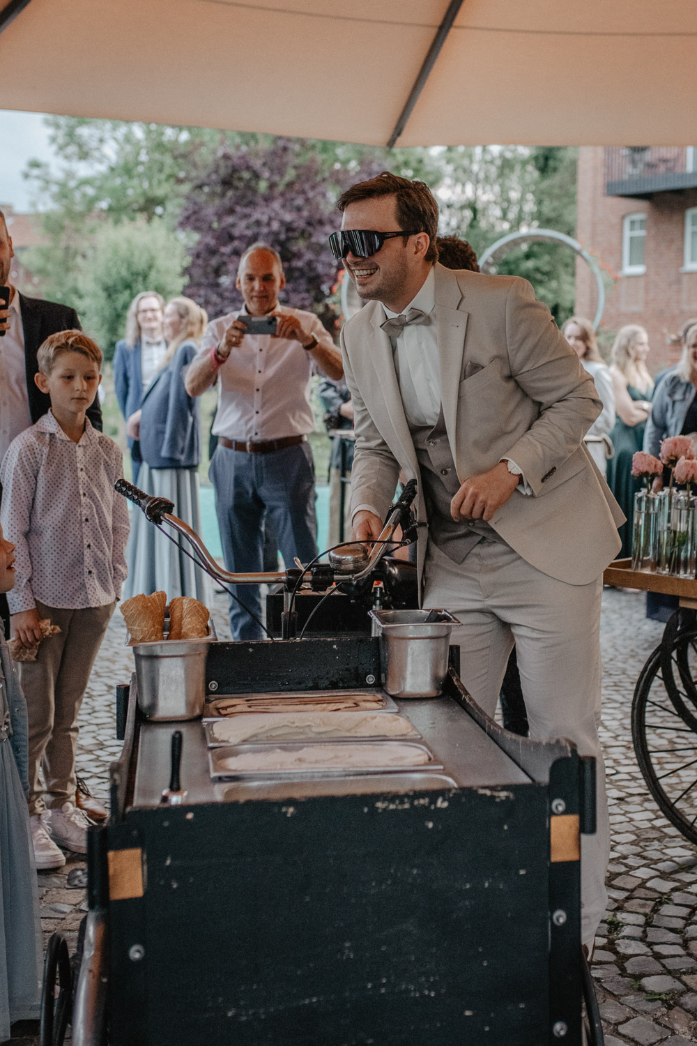 Bräutigam serviert Eis an Gäste bei der Hochzeit