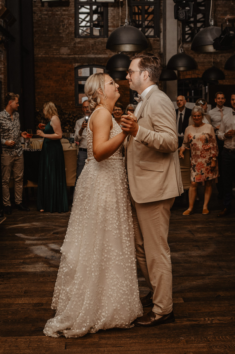 Brautpaar tanzt innig in rustikalem Hochzeitssaal