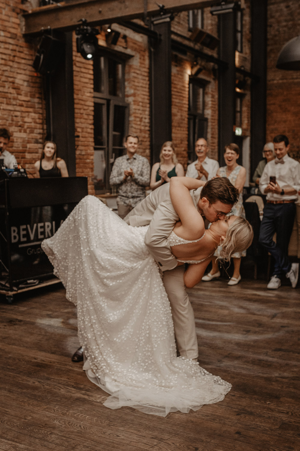 Bräutigam küsst Braut bei schwungvollem Tanz