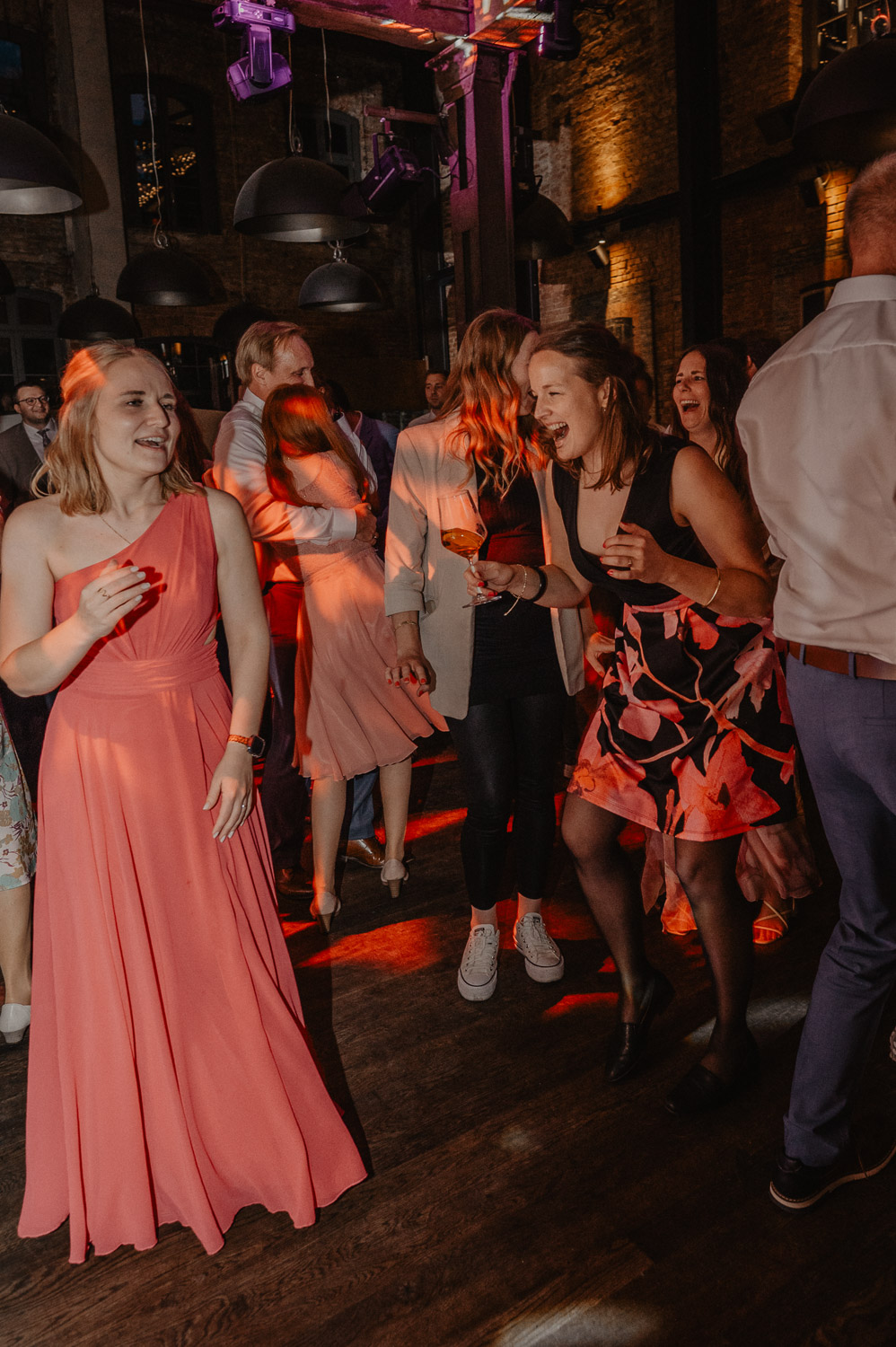 Gäste tanzen mit Drinks in der Hand auf Hochzeit