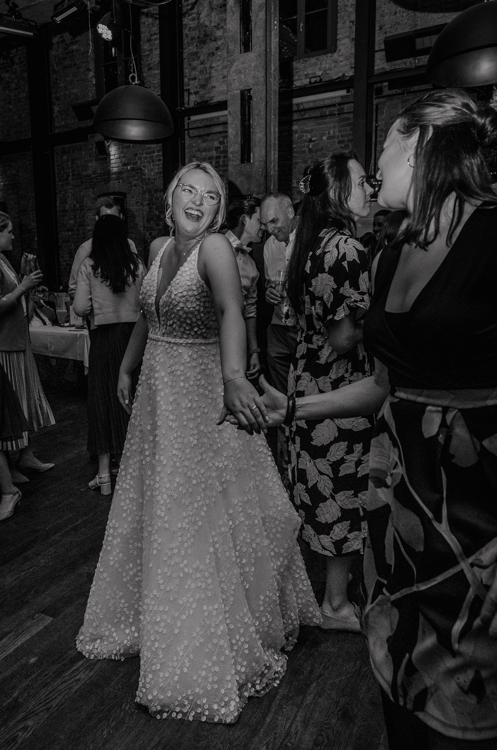 Braut tanzt lachend mit Freundin auf der Hochzeit