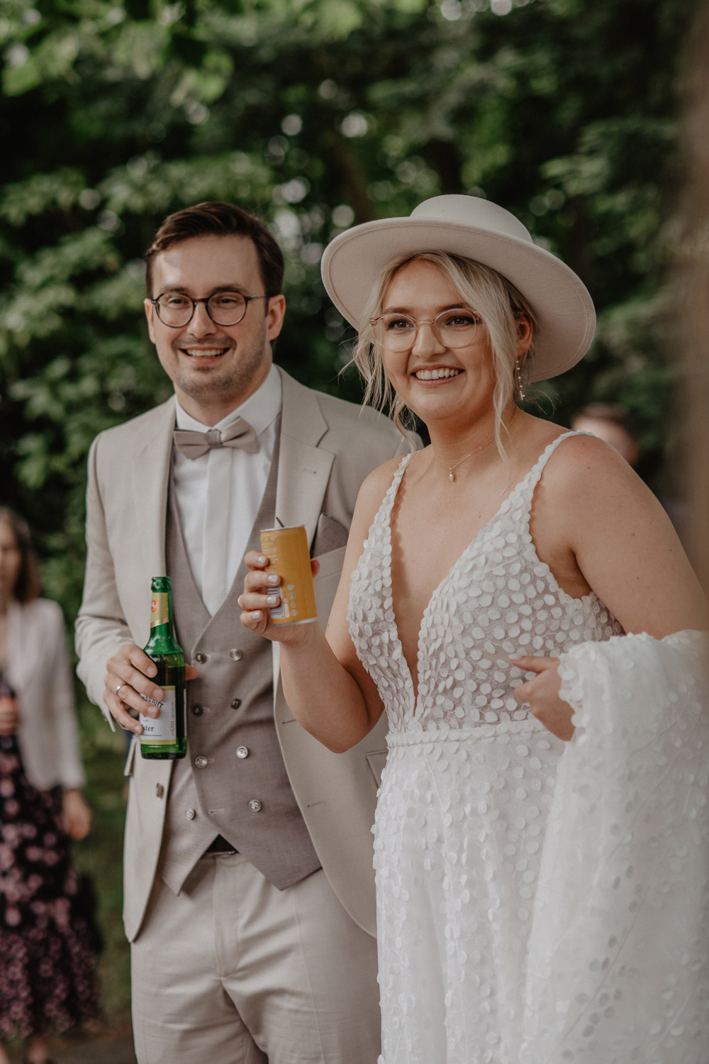 Braut und Bräutigam stoßen mit Getränken auf ihre Hochzeit an