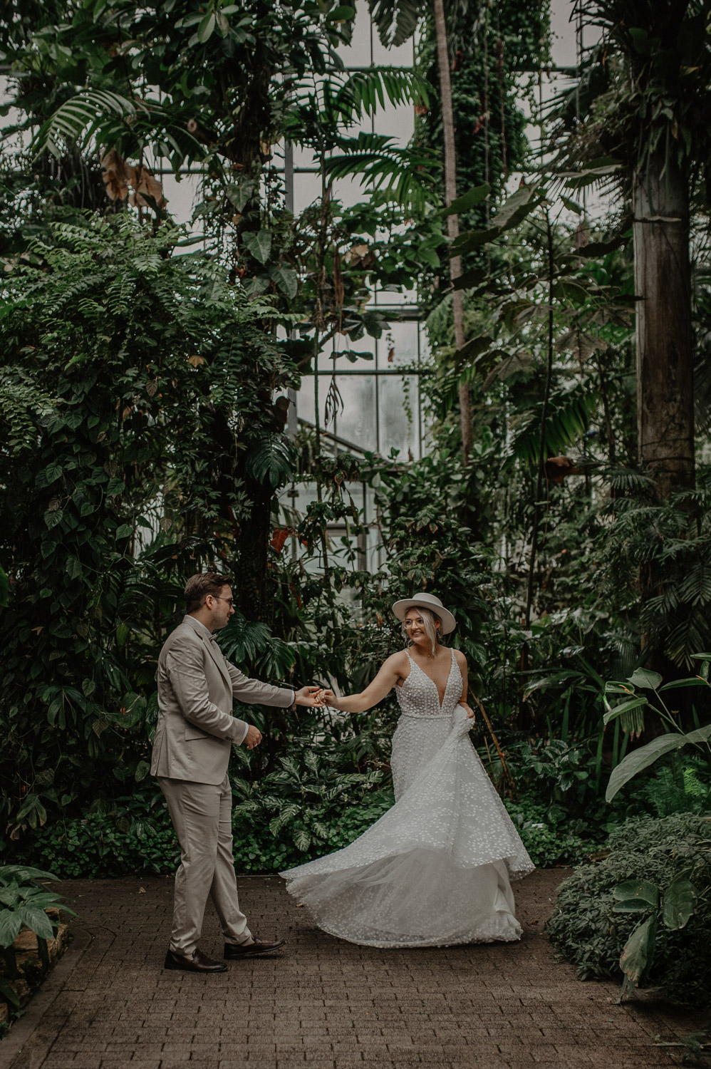 Braut dreht sich lachend beim Tanz im Tropenhaus