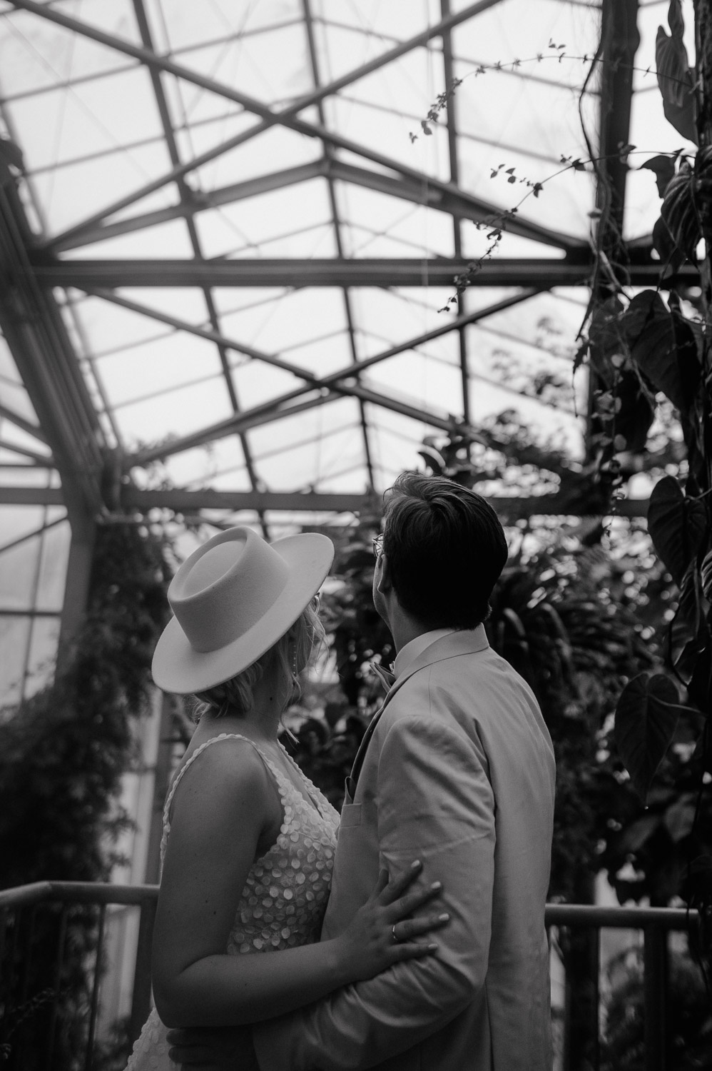 Brautpaar blickt gemeinsam ins Glasdach des Tropenhauses