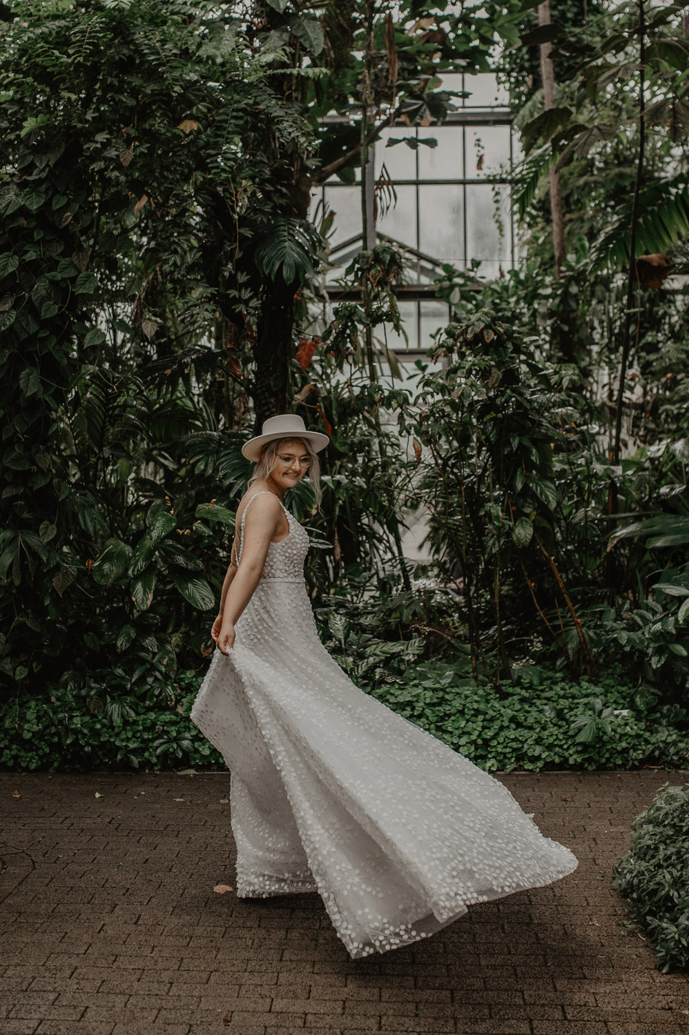 Braut dreht sich lachend im Tropenhaus