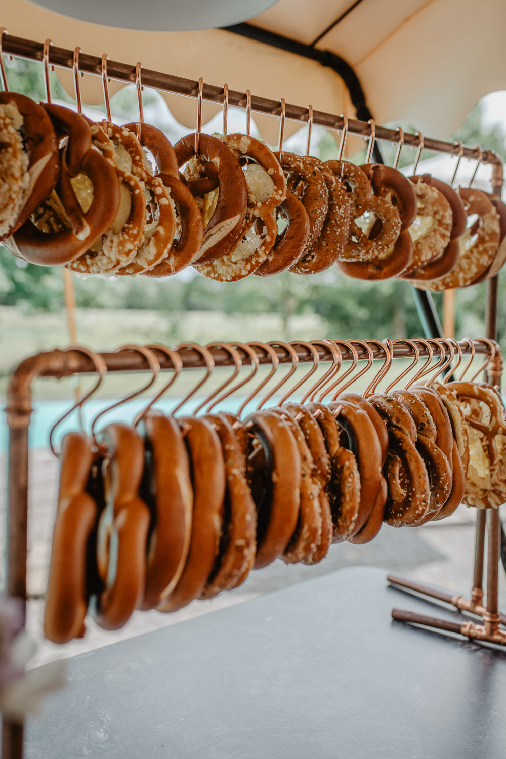 Brezeln hängen an kupferfarbenen Stangen zur Hochzeit