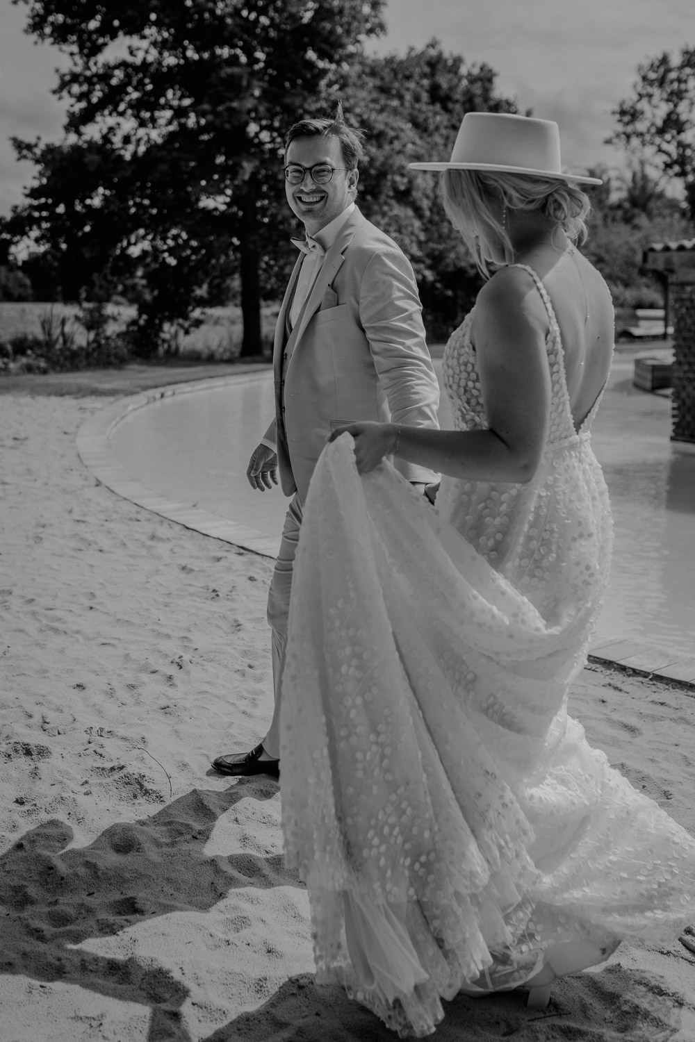 Brautpaar lacht gemeinsam am Sandstrand der Location