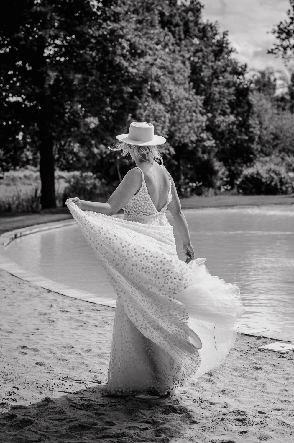 Braut dreht sich im Kleid am Sandstrand der Location