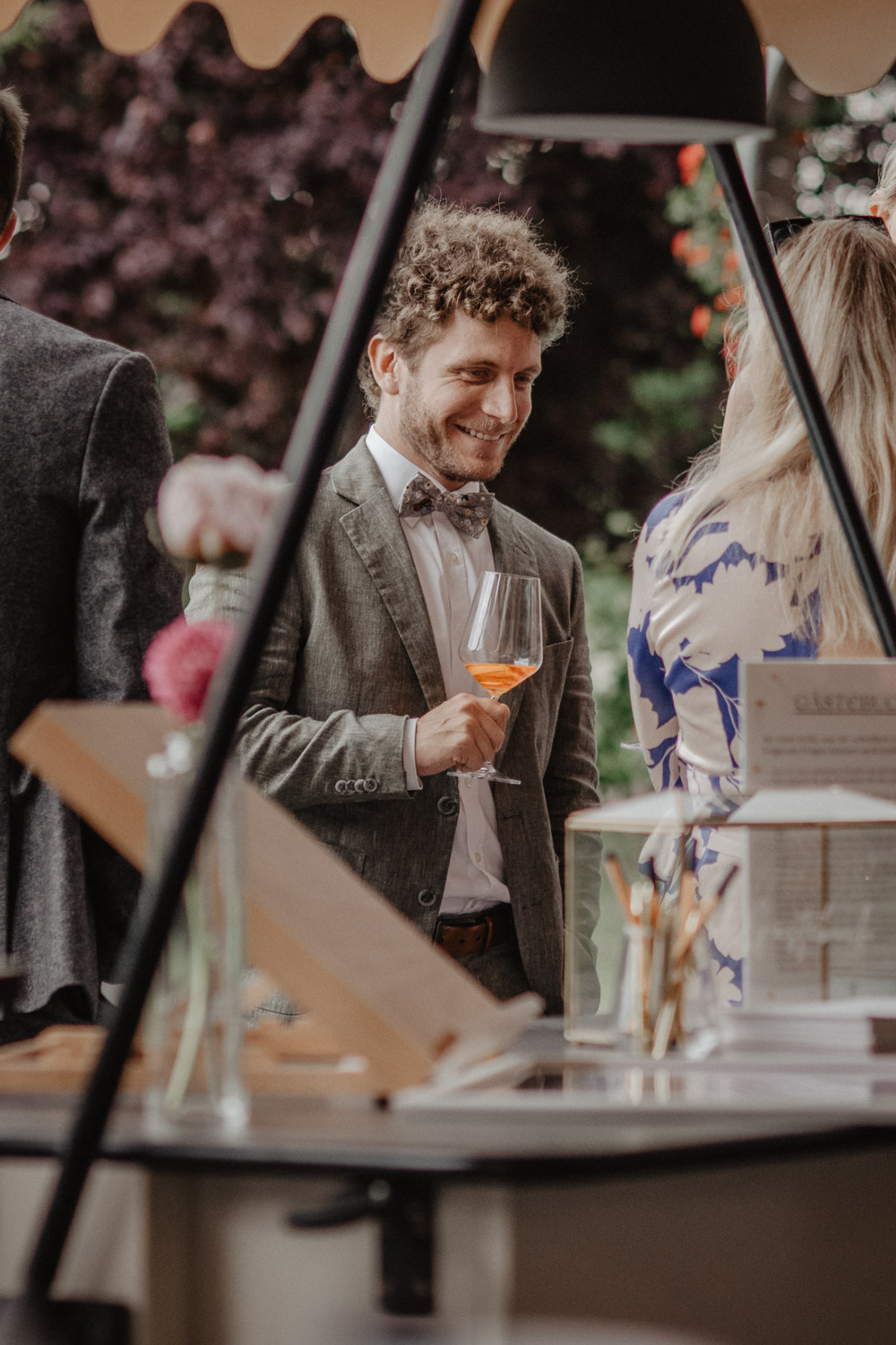 Mann im Anzug lächelt mit Glas in der Hand