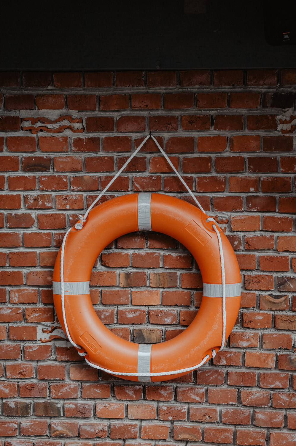 Orangener Rettungsring an Backsteinwand