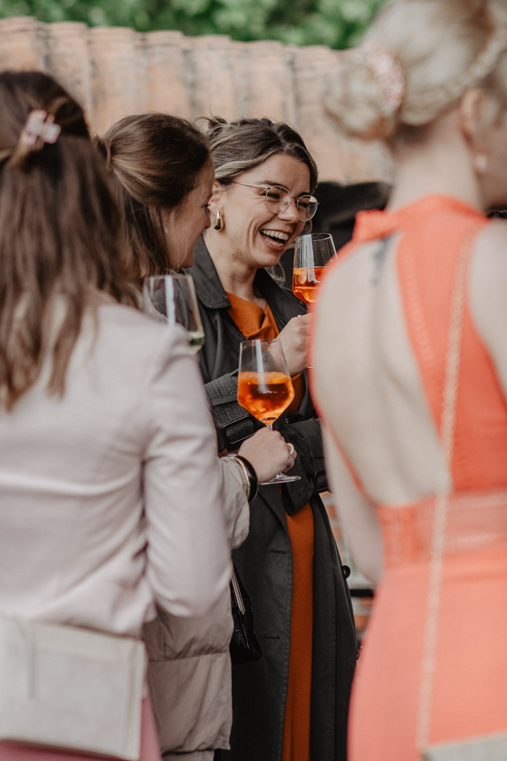 Frauen stoßen lachend mit Aperol an
