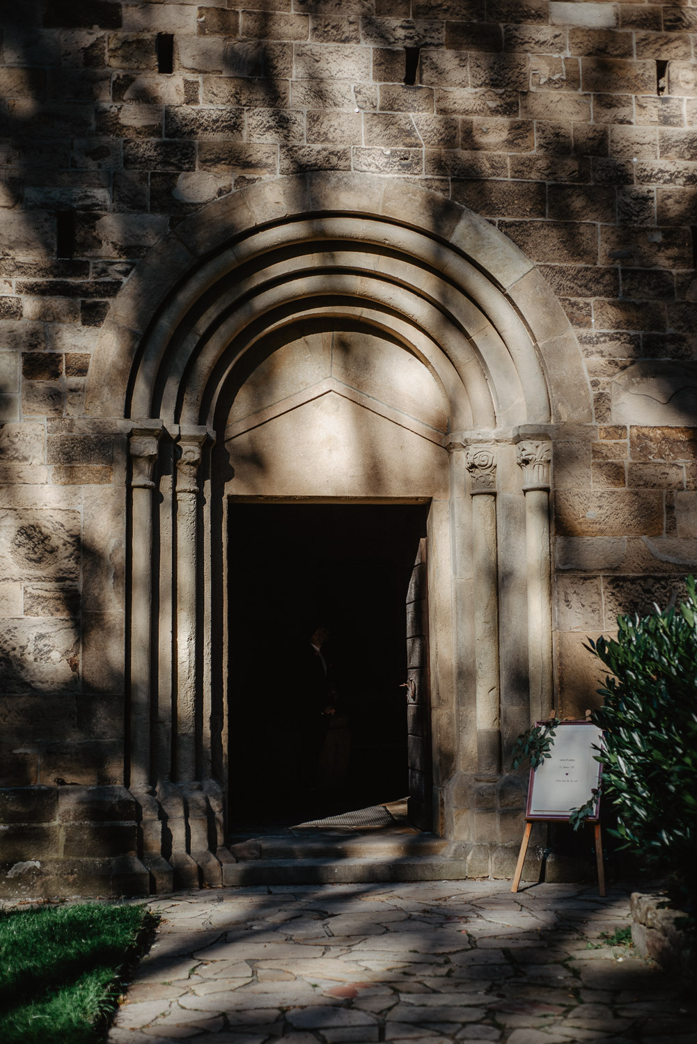 Historisches Kirchenportal im Sonnenlicht vor der Trauung.